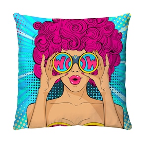 May include: Square throw pillow with a pop art design. The pillow features a woman with pink hair and sunglasses that say "WOW". The background is blue with white radial lines and dots. The woman has pink lips and is wearing a yellow top.
