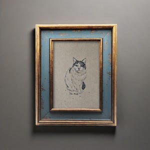 May include: A framed cat sketch. The artwork features a detailed black and white drawing of a seated cat on a neutral background. The frame has a distressed blue finish with gold accents, adding a vintage aesthetic.