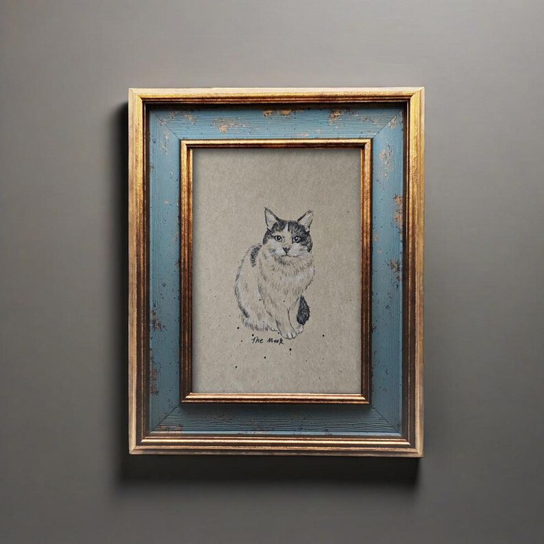 May include: A framed cat sketch. The artwork features a detailed black and white drawing of a seated cat on a neutral background. The frame has a distressed blue finish with gold accents, adding a vintage aesthetic.