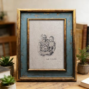 May include: A rectangular picture frame with a distressed teal and gold finish. The frame holds a black and white sketch of a woman and a baby. The text "Jack & grandma" is written below the sketch.