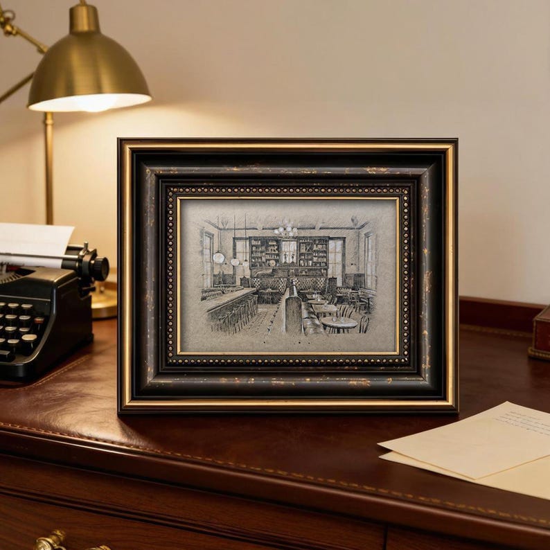 May include: A framed black and gold sketch of a restaurant interior. The frame has a distressed look with a gold inner border. The sketch depicts tables, chairs, and a bar area, creating a vintage aesthetic.