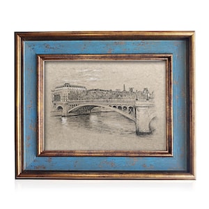 May include: A framed print featuring a detailed black and white drawing of a bridge over water. The frame has a distressed blue outer edge and a gold inner edge. The artwork depicts a landscape scene, creating a vintage aesthetic.