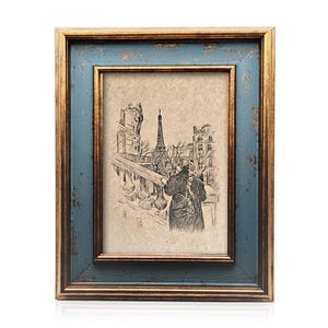 May include: A framed sketch of the Eiffel Tower and a person in Paris. The frame has a distressed blue outer edge and a gold inner edge. The artwork is in a rectangular format.