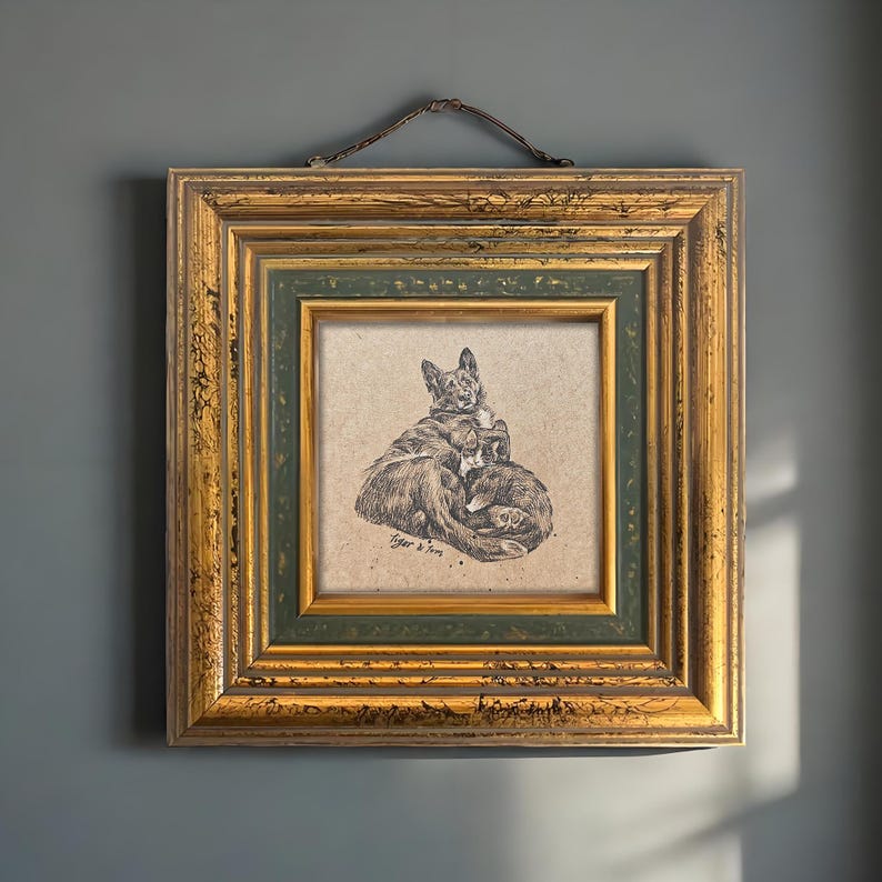 May include: A framed pen and ink drawing of two dogs, one lying on top of the other. The artwork is in a gold and green ornate frame, with a brown hanging cord. The drawing is signed "Tiger & Tom".