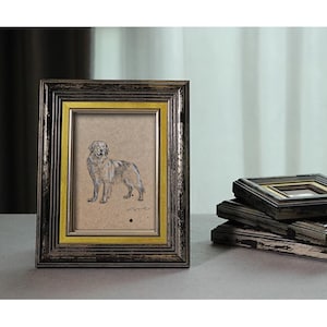 May include: A black and gold picture frame with a drawing of a dog inside. The frame has a distressed look and is made of wood.