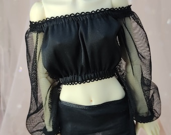 May include: A black off-the-shoulder crop top featuring long, sheer mesh puff sleeves with a scalloped trim along the neckline and hem. The garment is paired with a matching black mini skirt, creating a coordinated two-piece set for a doll.