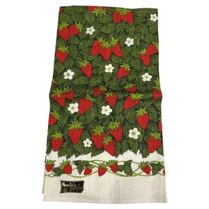 May include: A vintage kitchen towel with a vibrant strawberry pattern. The design features red strawberries, white flowers, and green leaves on a dark green background. The bottom border is white with a strawberry and leaf design. The towel has a tag that reads "Kay Dee".