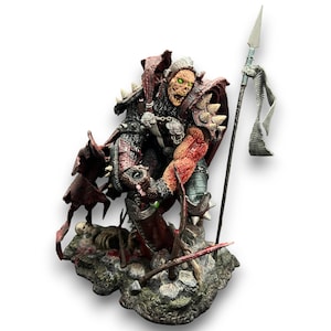 May include: A detailed action figure of a monstrous character, featuring a decaying face with green eyes, spiked armour, and a red cape. The figure is holding a spear with a tattered banner and stands on a rocky base with bones and weapons.
