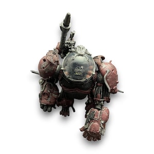 Puede incluir: Vista superior detallada de una figura de robot mecánico. El robot es principalmente rojo y gris, con detalles intrincados y una cabeza transparente en forma de burbuja. Tiene un gran cañón adjunto a su espalda y parece ser un juguete coleccionable.