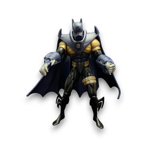 May include: A Batman action figure with a dark blue cape and cowl, yellow chest, and black and gold accents. The figure has articulated joints and is posed in a dynamic stance. The figure is approximately 15 cm tall.