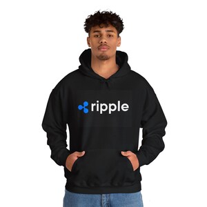 Puede incluir: Sudadera con capucha negra con un logotipo "ripple" blanco y un símbolo ripple azul.