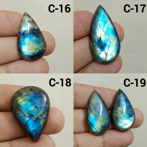 Peut inclure: Quatre pierres pr&eacute;cieuses de labradorite polies en forme de goutte d'eau. Les pierres pr&eacute;sentent des reflets iris&eacute;s bleus, verts et dor&eacute;s. Chaque pierre est &eacute;tiquet&eacute;e avec un "C" suivi d'un num&eacute;ro, de 16 &agrave; 19.