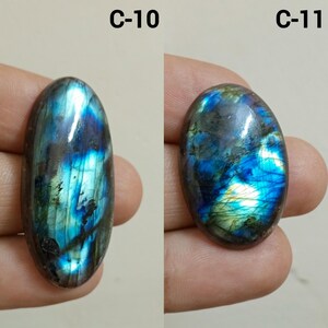 Peut inclure: Deux pierres pr&eacute;cieuses de labradorite ovales. Les pierres pr&eacute;sentent des reflets iris&eacute;s bleus, verts et dor&eacute;s. La pierre de gauche est &eacute;tiquet&eacute;e "C-10" et celle de droite "C-11".