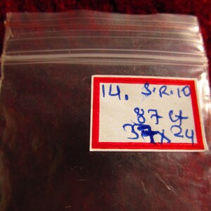 Puede incluir: Una etiqueta blanca con borde rojo y escritura azul. La etiqueta dice "14. S'R. 10 87 Ct 37x24".