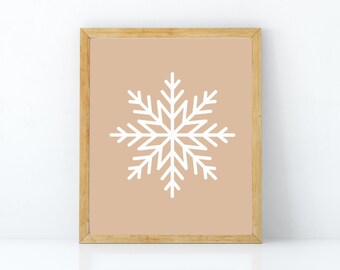 Könnte beinhalten: Ein gerahmter Druck mit einem weißen Schneeflocken-Design auf einem hellbraunen Hintergrund. Der Rahmen ist aus Naturholz.