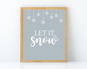 Könnte beinhalten: Ein gerahmter Druck mit hellblauem Hintergrund und weißen Schneeflocken, die von oben hängen. Der Text "Let it snow" ist in weißer Kursivschrift geschrieben.