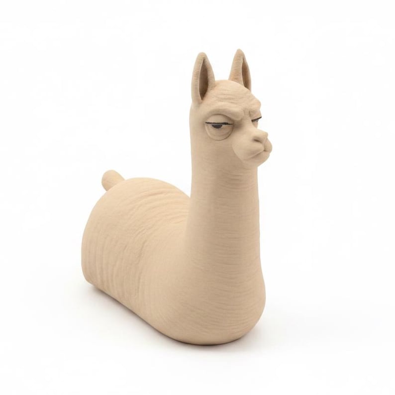 Puede incluir: Una figura de llama de color beige con superficie texturizada, orejas erguidas y una expresi&oacute;n facial con ojos entrecerrados y boca cerrada. La escultura tiene un cuerpo liso y redondeado con una peque&ntilde;a cola, en un tono neutro.