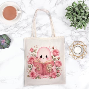Pink ghost reading book design on tote bag. Cute bookish coquette Halloween ghost with flowers, sublimation PNG.