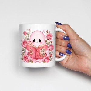 Pink ghost reading book design on white ceramic mug. Cute coquette Halloween ghost with flowers and open book, spooky season sublimation design.
