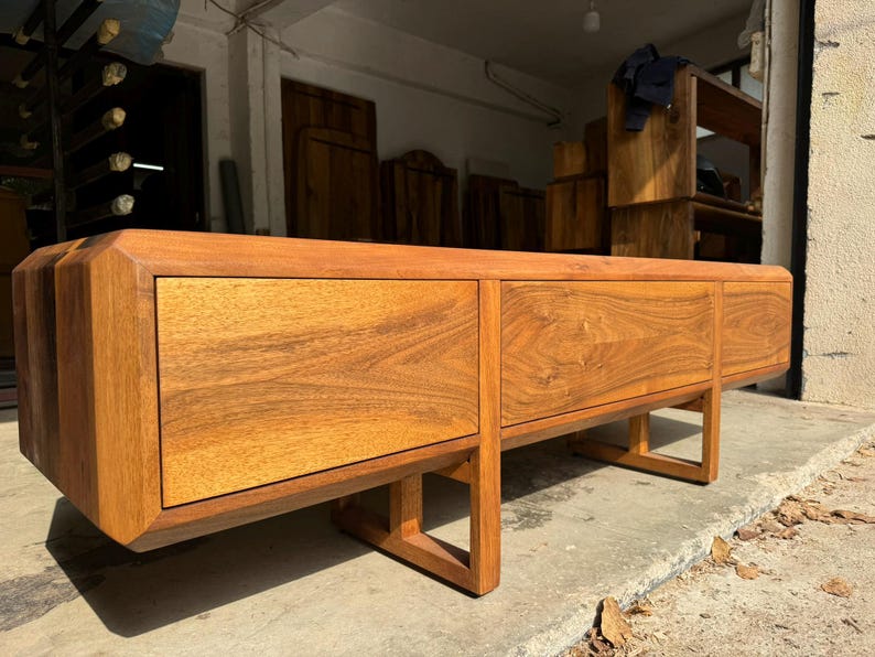 Handmade solid walnut TV stand with wooden legs, front view showing natural wood texture