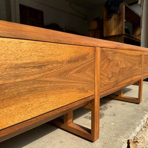 Wooden legs detail of solid walnut TV stand, precise joinery and smooth finish