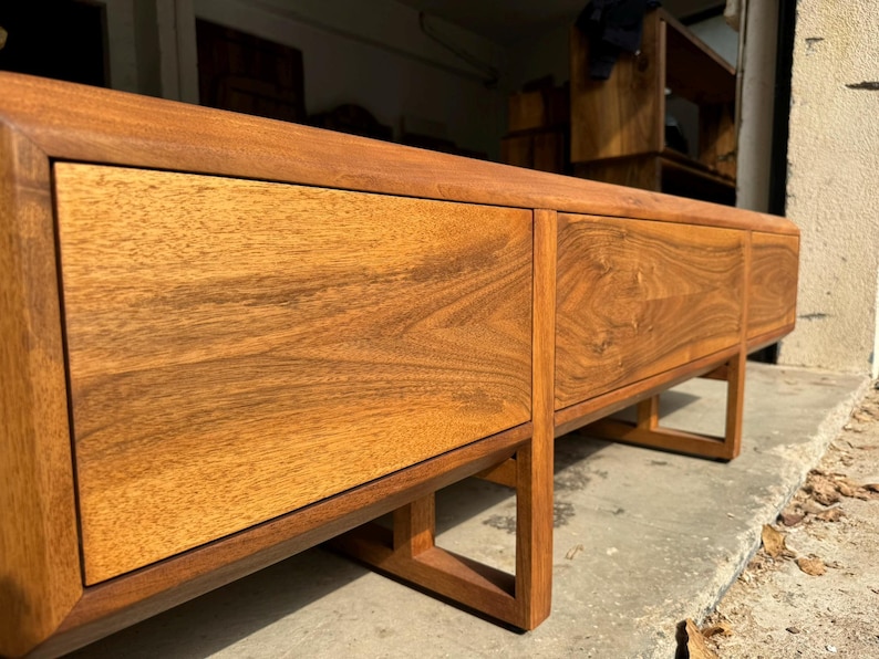 Wooden legs detail of solid walnut TV stand, precise joinery and smooth finish