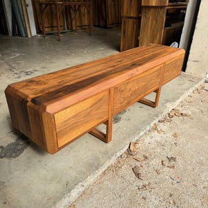 Finished walnut TV stand in workshop showcase before shipping
