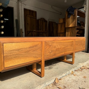 Modern walnut TV stand in handcrafted workshop lighting