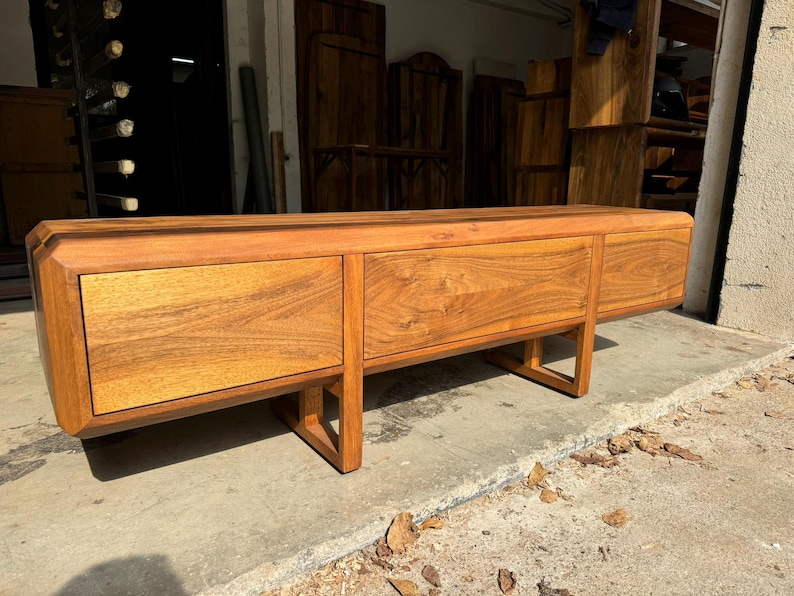 Handcrafted walnut TV unit standing on wooden legs, symbol of natural beauty and precision
