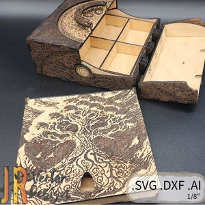 May include: A wooden box with a hinged lid and a tree design. The box has six compartments inside and is 1/8 inch thick. The lid has a tree design with a cutout in the centre.
