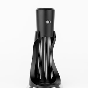 May include: A black coffee grinder with a silver base and a cylindrical top. The grinder has a unique design with vertical silver lines and the "LILO" logo on the top.