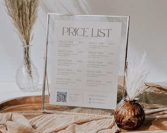 Puede incluir: Un marco de vidrio transparente muestra una lista de precios con el título "PRICE LIST". La lista incluye descripciones de servicios y precios. El marco está sobre una bandeja de madera con elementos decorativos.