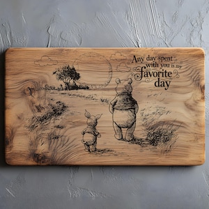 Op de afbeelding: Een rechthoekige houten snijplank met een illustratie van Winnie de Poeh en Knorretje. Het kunstwerk toont de personages in een veld, met de tekst "Any day spent with you is my favorite day".