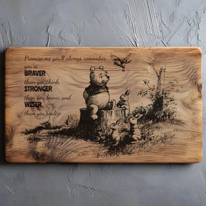 May include: A rectangular wooden cutting board featuring a laser-engraved illustration of Winnie the Pooh sitting on a tree stump with rabbits and a bird. The text reads: Promise me you'll always remember: you're BRAVER than you think, STRONGER than you know, and WISER than you realize.