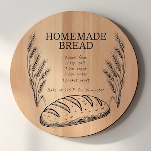May include: A round wooden cutting board with the words "HOMEMADE BREAD" and a bread recipe. The recipe includes 3 cups of flour, 1 tsp salt, 1 tsp sugar, 1 cup water, and 1 packet yeast. Bake at 375°F for 30 minutes. Wheat stalks and a bread illustration are also included.