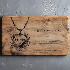 May include: A wooden cutting board with the words "MILITARY MOM" and a definition. A heart-shaped pendant with "U.S. ARMY" is engraved on the board. The board has a natural wood grain pattern.