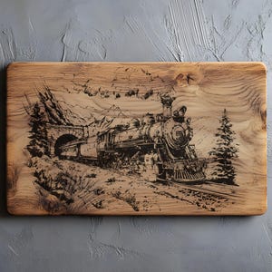 May include: A rectangular wooden serving board with a detailed black engraving of a steam train emerging from a tunnel in a mountain landscape. The board has a natural wood grain finish.