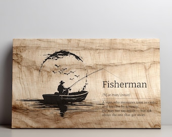 Puede incluir: Arte de pared de madera con una ilustración en tinta negra de un pescador en un bote, con pájaros volando por encima. La palabra "Fisherman" está impresa en negro, junto con una definición.