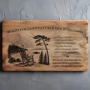 May include: A rectangular wooden board featuring a laser-engraved illustration of a rocking chair by a lake at sunset. The text reads: REZEPT F&Uuml;R EINEN GL&Uuml;CKLICHEN RUHESTAND, followed by a list of ingredients and instructions in German.
