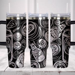 May include: A black and silver stainless steel tumbler with a handle and a straw. The tumbler has a design of beer cans, bottle caps, and the words "Craft Beer".