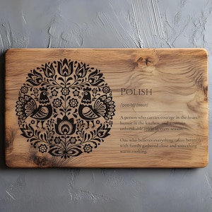 Puede incluir: Tabla de cortar rectangular de madera con un diseño decorativo floral y de pájaros en negro. La palabra "POLISH" está impresa en la tabla, junto con una definición. Un accesorio de cocina.