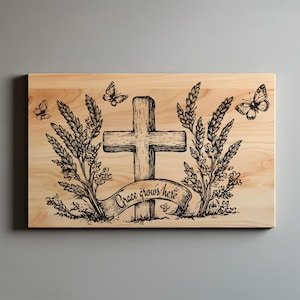 May include: Wooden plaque with a cross, wheat stalks, and butterflies. The phrase "Grace grows here" is written on a banner below the cross. The artwork is etched in black on a light wood background.