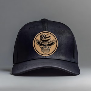 May include: Black baseball cap with a circular patch featuring a skull wearing a cowboy hat with an American flag design. The hat and skull are in a tan color, set against a black cap.