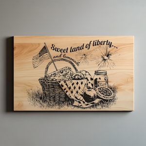 May include: A wooden cutting board with a picnic scene etched into the surface. The design includes a basket, an American flag, food items, and the text "Sweet land of liberty... and lemonade."