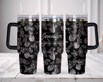May include: Three stainless steel travel mugs with black and white strawberry designs. The middle mug has the name "Jennifer" engraved on it.