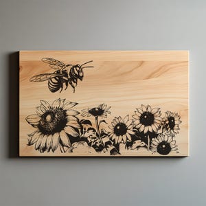 May include: A wooden cutting board with a black and white illustration of a bee flying over a field of sunflowers.