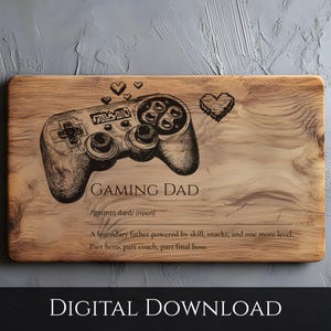 Op de afbeelding: Houten snijplank met een gedetailleerde gravure van een videogamecontroller en de woorden "GAMING DAD". De beschrijving hieronder definieert "Gaming Dad" als een legendarische vader. Pixelhartjes zijn ook in het ontwerp opgenomen.