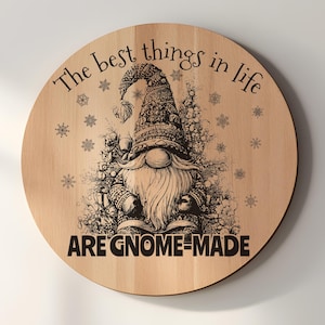 May include: Round wooden sign with a gnome illustration and the text "The best things in life are gnome-made." The gnome has a long white beard and is wearing a patterned hat and sweater. Snowflakes are scattered around the gnome.