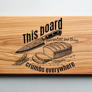 Pode incluir: Uma tábua de cortar de madeira com o texto "This board guarantees one thing: crumbs everywhere" e um desenho de uma faca, pão e trigo.