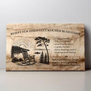 May include: A rectangular wooden sign with a light brown wood grain texture. It features a black laser-engraved illustration of a rocking chair by a lake at sunrise, alongside German text listing a recipe for a happy retirement.